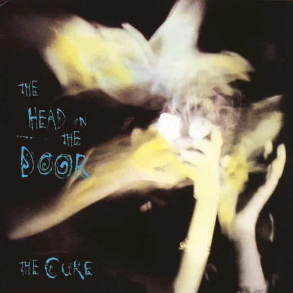Album cover of 'The Head on the Door' by The Cure with a blurred image of a person and text.